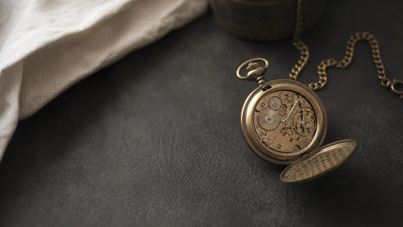 Open vintage pocket watch on a leather desk